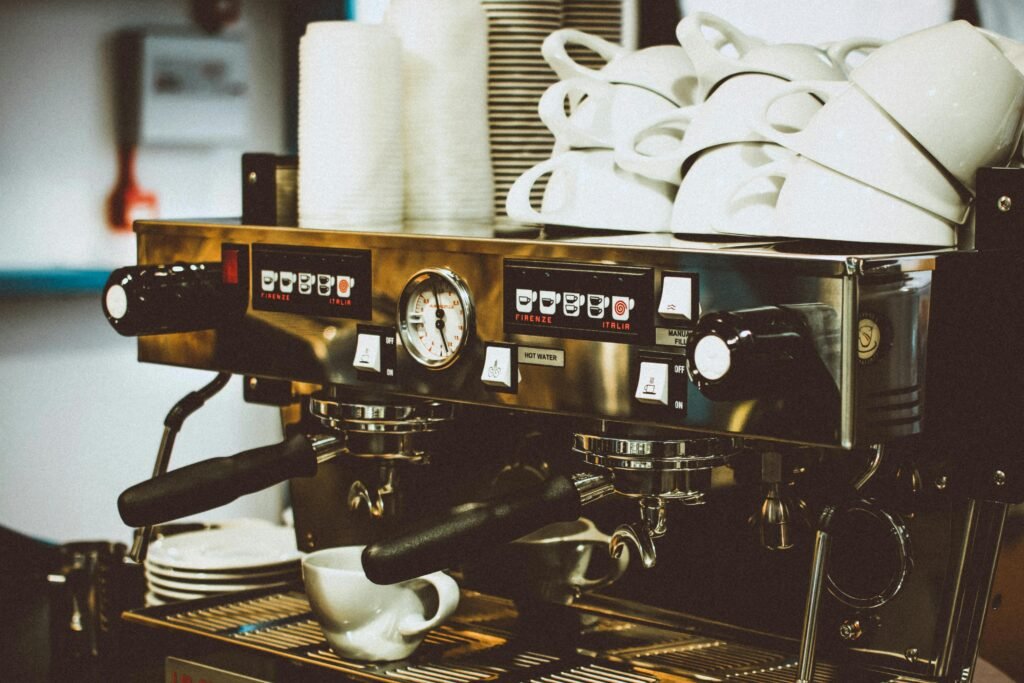 Image of a professional espresso machine with cups in a cozy café environment.